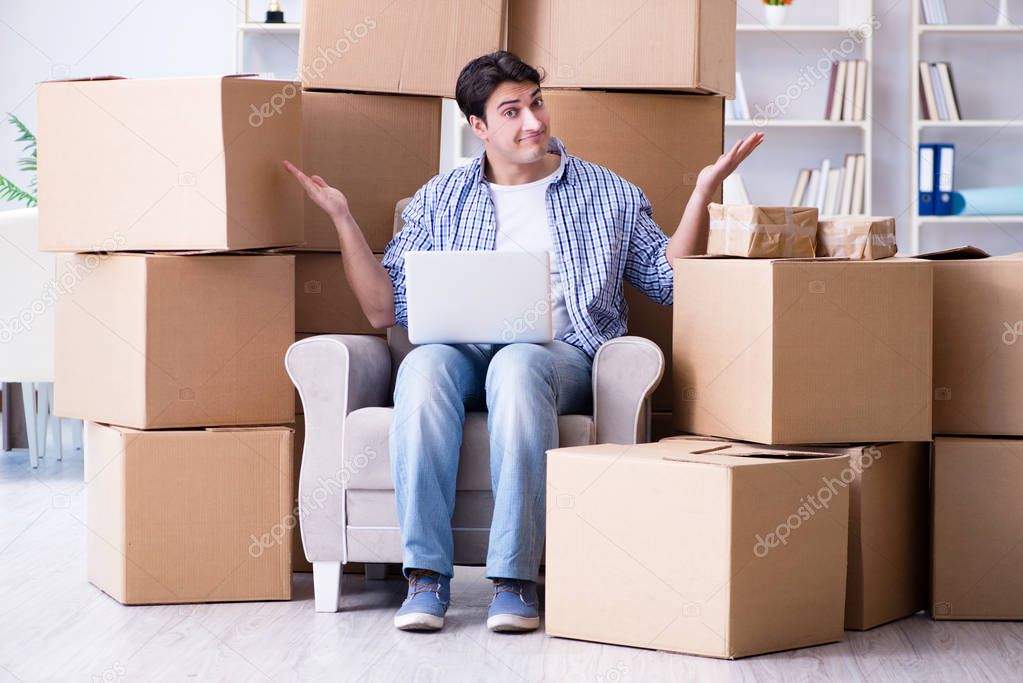 Young man moving in to new house with boxes