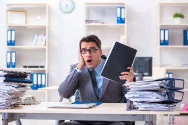 Fazla mesai, evrak işi yükü altında.