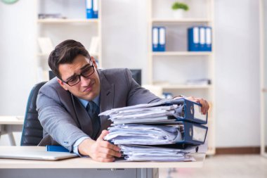 Fazla mesai, evrak işi yükü altında.