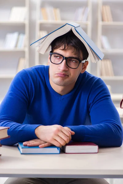 Mannelijke student bereidt zich voor op examens in universiteitsbibliotheek — Stockfoto