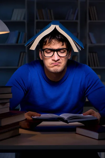 Estudante se preparando para exames tarde da noite na biblioteca — Fotografia de Stock