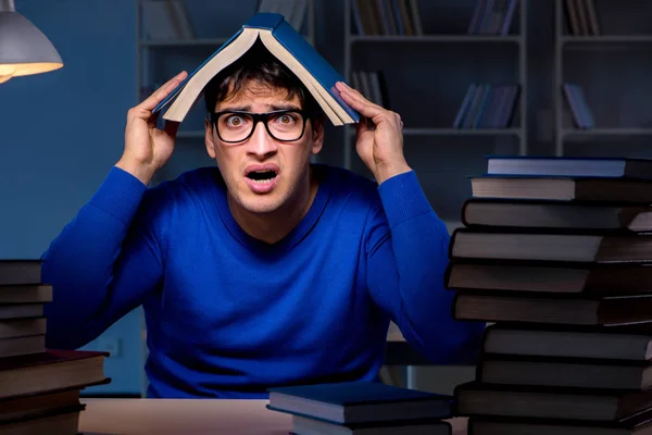 Estudante se preparando para exames tarde da noite na biblioteca — Fotografia de Stock