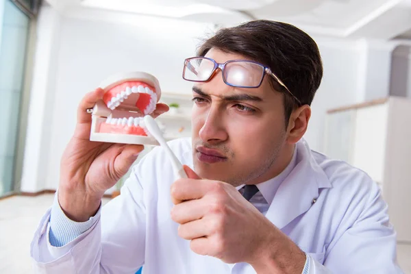 Funny dentist with toothbrush in medical concept