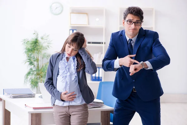 Беременная женщина борется в офисе и получить коллегу он — стоковое фото