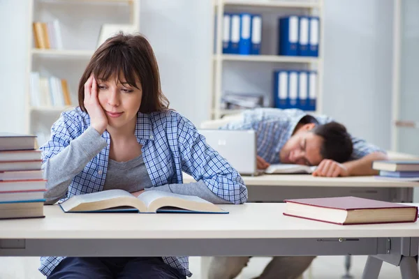 Estudiantes sentados y estudiando en la universidad — Foto de Stock