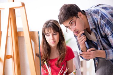 Stüdyoda resim sınıfında sanatçı koçluğu yapan bir öğrenci.