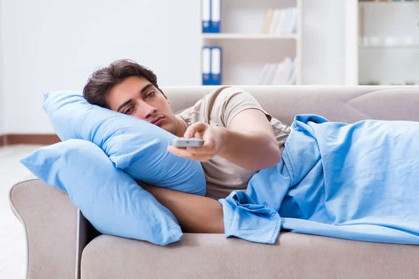 Mann mit Fernbedienung im Bett vor Fernseher — Stockfoto