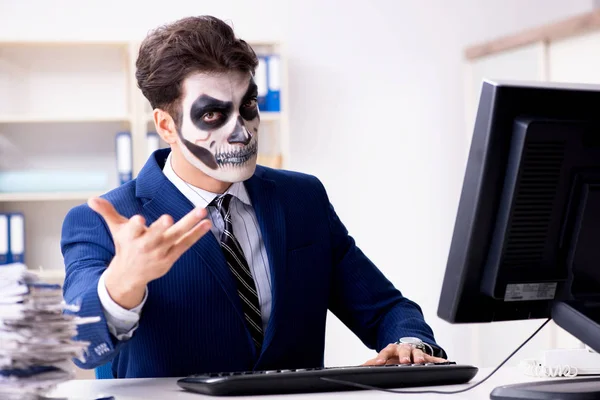 Businessmsn s děsivou obličejovou maskou pracující v kanceláři — Stock fotografie