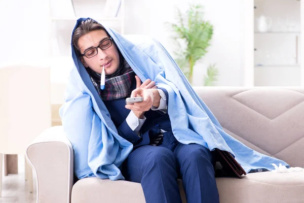 Empleado hombre de negocios viendo la televisión mientras está enfermo de gripe — Foto de Stock