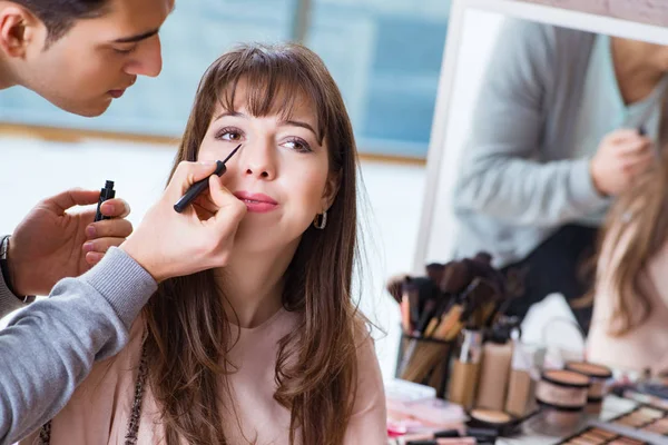 Uomo che fa il make-up per la donna carina nel salone di bellezza — Foto Stock