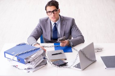 Ofis masasına zincirlenmiş meşgul bir çalışan.