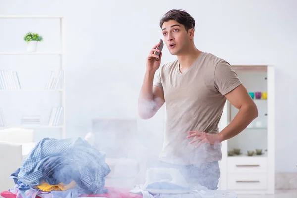 Unaufmerksamer Ehemann verbrennt Kleidung beim Bügeln — Stockfoto