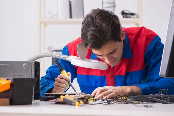 Professional repairman repairing computer in workshop