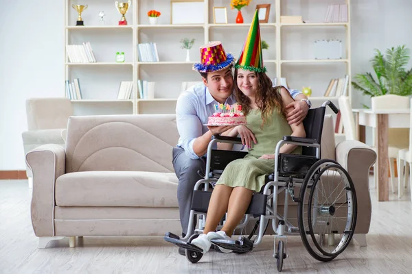 Joven familia celebrando cumpleaños con persona discapacitada —  Fotos de Stock