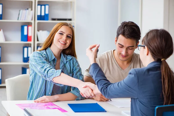 Young family agreeing mortgage contract in the bank for new house