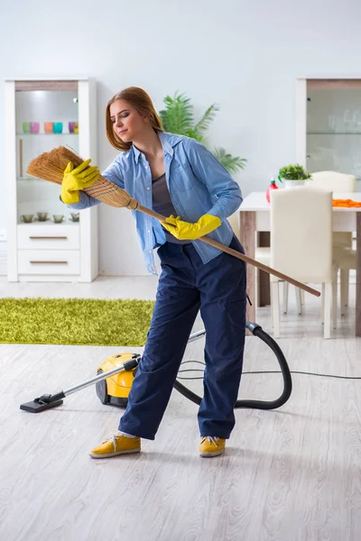 Junge Frau putzt Fußboden zu Hause und erledigt Hausarbeiten — Stockfoto