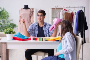 Hamile kadın yeni kıyafet için terziye gidiyor.