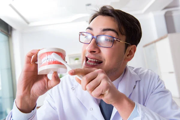 Funny dentist with toothbrush in medical concept