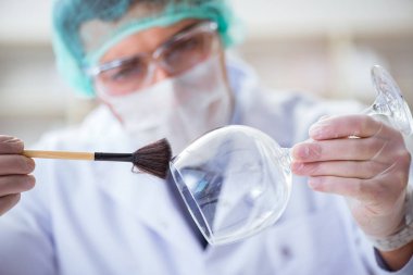 Adli tıp dedektifi suç delilleri üzerinde çalışıyor.