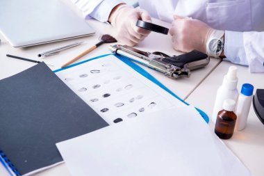 Kriminolog polis kimyageri suç delillerine bakıyor.