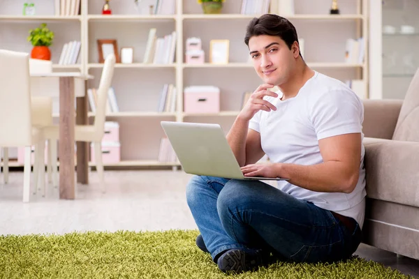 Mann arbeitet zu Hause am Laptop auf Teppichboden — Stockfoto