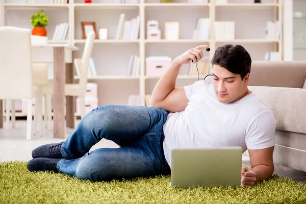 Hombre trabajando en el ordenador portátil en casa en el suelo de la alfombra — Foto de Stock