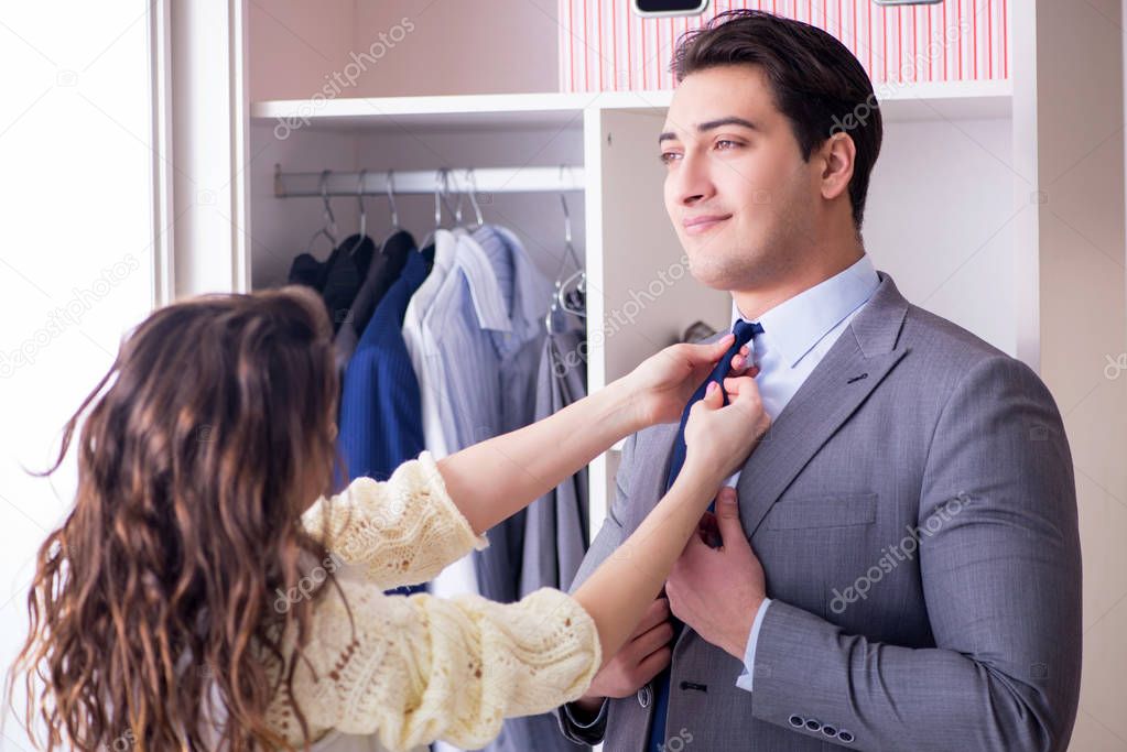 Wife helping husband to get dressed up