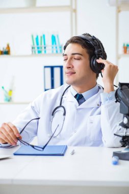 Hastanede öğle arasında müzik dinleyen mutlu doktor.