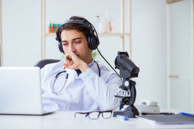 Male doctor listening to patient during telemedicine session clipart
