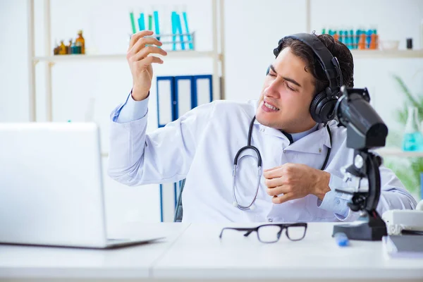 Ευτυχισμένος ενθουσιασμένος γιατρός ακούγοντας μουσική κατά τη διάρκεια του διαλείμματος στο νοσοκομείο — Φωτογραφία Αρχείου