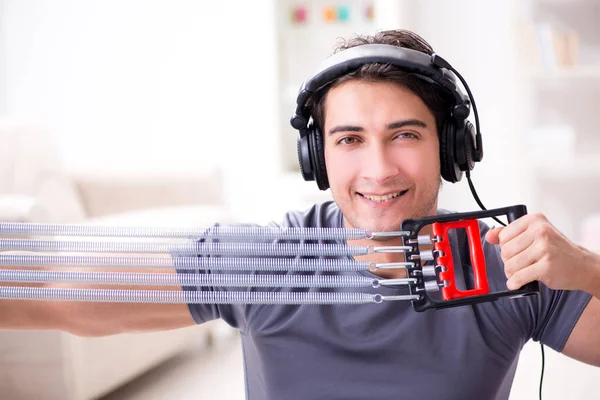 Man die sport beoefent met verzetsband en naar muziek luistert — Stockfoto