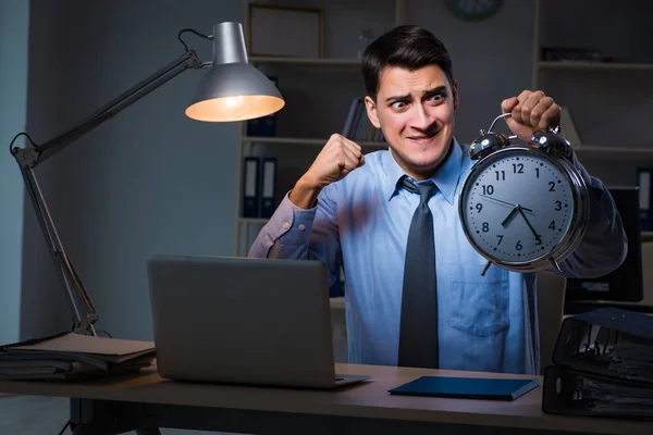 Jovem empregado que trabalha horas extras para cumprir prazo — Fotografia de Stock