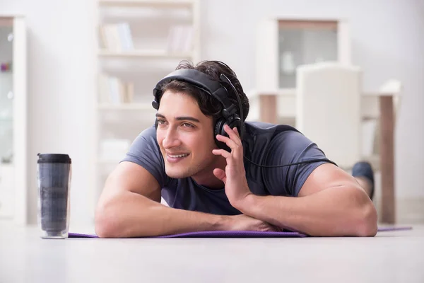 Man doing sports at home and listening to music — Stock Photo, Image