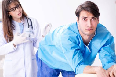 Komik adam şırınga iğnesine hazırlanıyor.