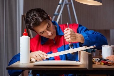 Genç adam ahşap parçaları DIY konseptinde yapıştırıyor.