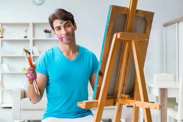 Jovem artista engraçado trabalhando em nova pintura em seu estúdio — Fotografia de Stock