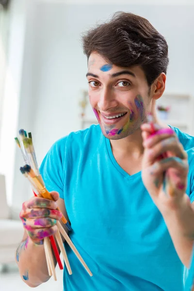 Jonge grappige kunstenaar werkt aan nieuw schilderij in zijn atelier — Stockfoto