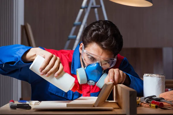 Junger Mann klebt Holzteile in DIY-Konzept zusammen — Stockfoto