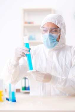 Laboratuvarda kimyasallar üzerinde çalışan genç bir kimyager.