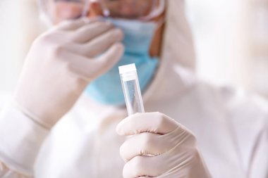 Laboratuvarda kimyasallar üzerinde çalışan genç bir kimyager.