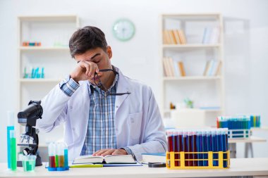 Laboratuvarda kimyasallar üzerinde çalışan genç bir kimyager.