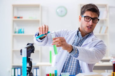 Laboratuvarda kimyasallar üzerinde çalışan genç bir kimyager.