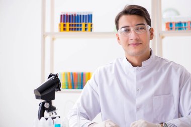 Laboratuvarda kimyasallar üzerinde çalışan genç bir kimyager.