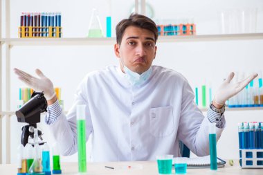 Laboratuvarda kimyasallar üzerinde çalışan genç bir kimyager.
