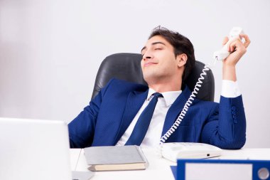 İşadamı ofis telefonundan konuşuyor.