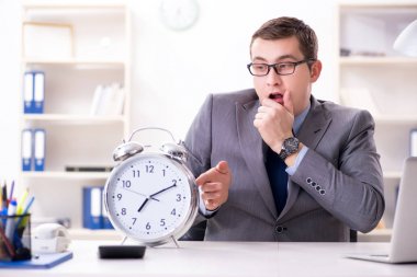 Acil ve son teslim tarihi konseptinde alarm veren bir işadamı. 