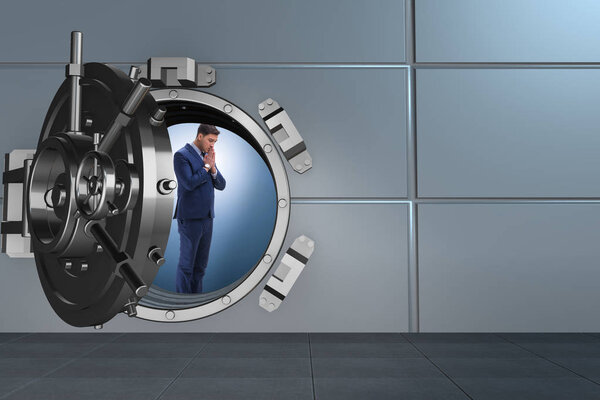 Businessman concerned about theft at banking vault door