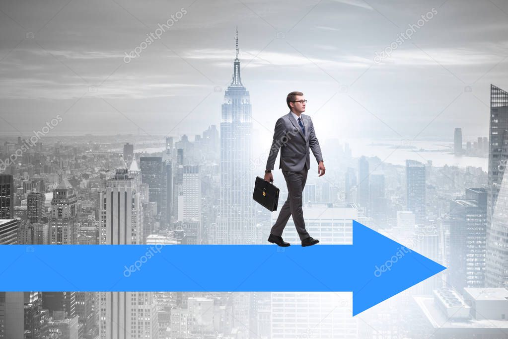 Businessman walking on arrow in business concept