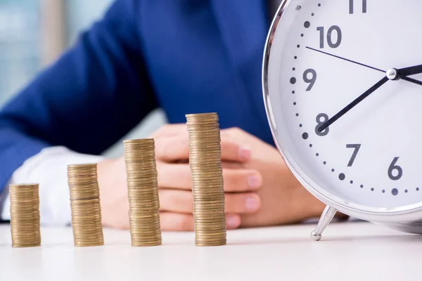 Empresario con pilas de monedas en la oficina — Foto de Stock