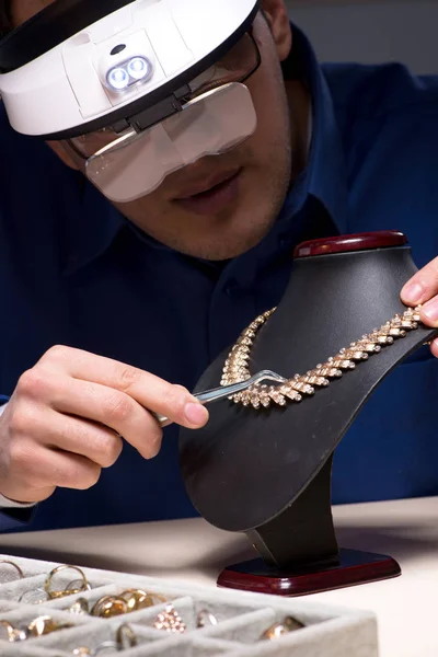 Jeweler pracuje ve své dílně pozdě v noci — Stock fotografie